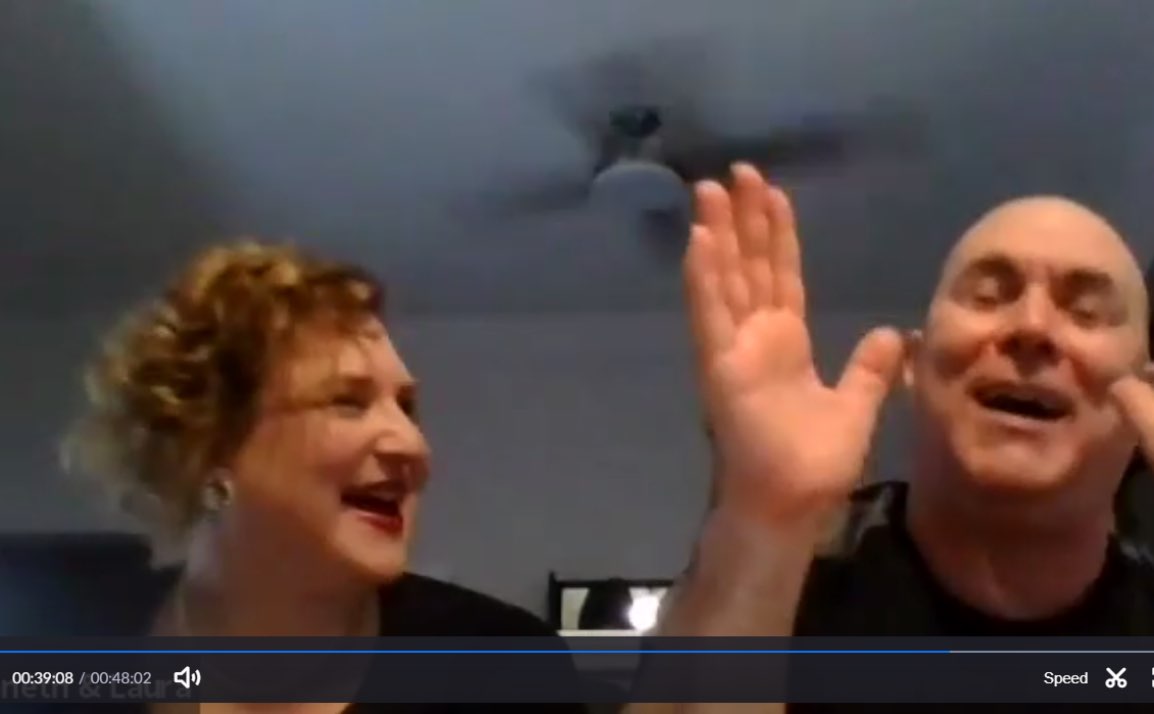Screen shot of couple laughing. Man is clapping.